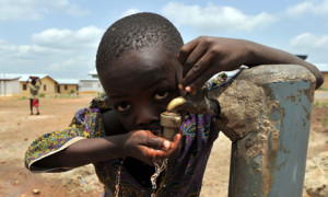 A boy drinks from a water tap in Sierra Leone